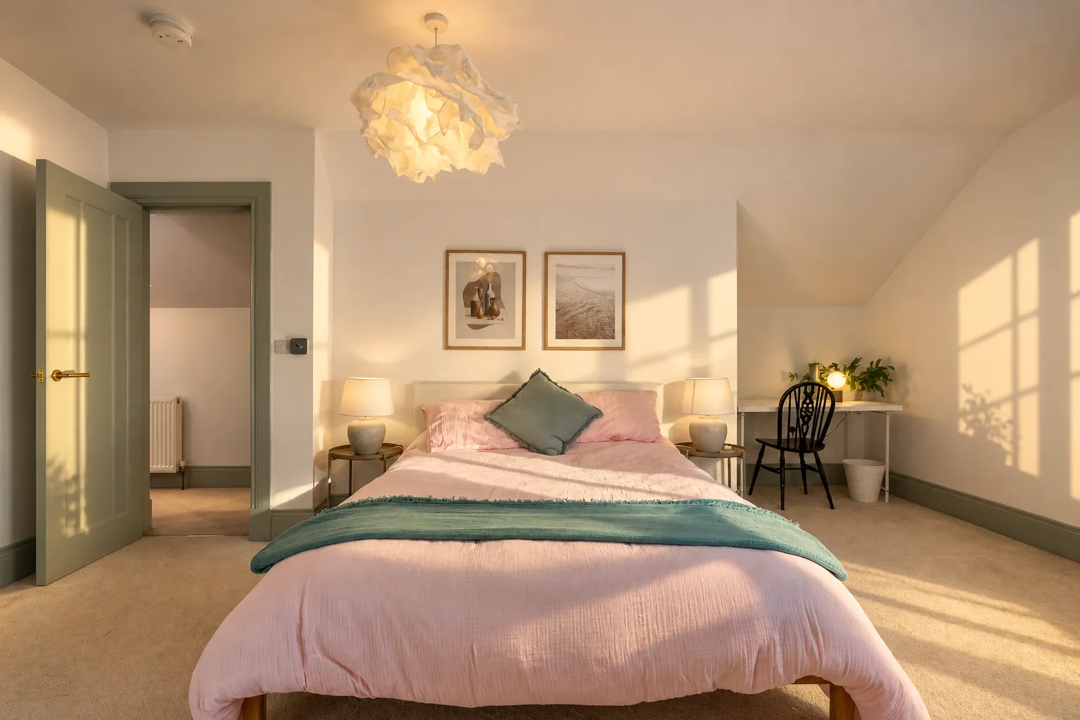 Cottage bedroom with pink linen and sage door frames, window light on the wall, North Coast